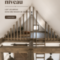 Un loft moderne aménagé dans une barn house avec des matériaux bruts et un mobilier chaleureux.